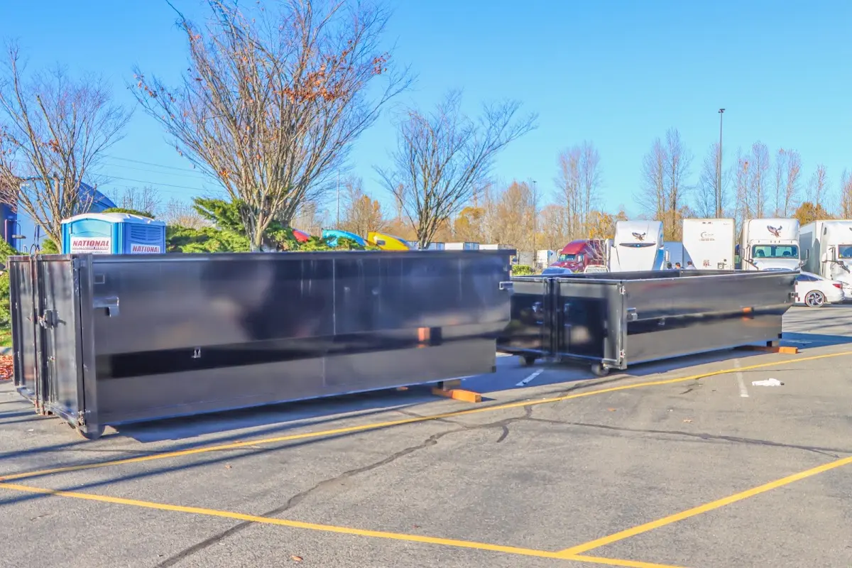 Professional dumpster rental service with roll-off container on residential driveway in Newtown
